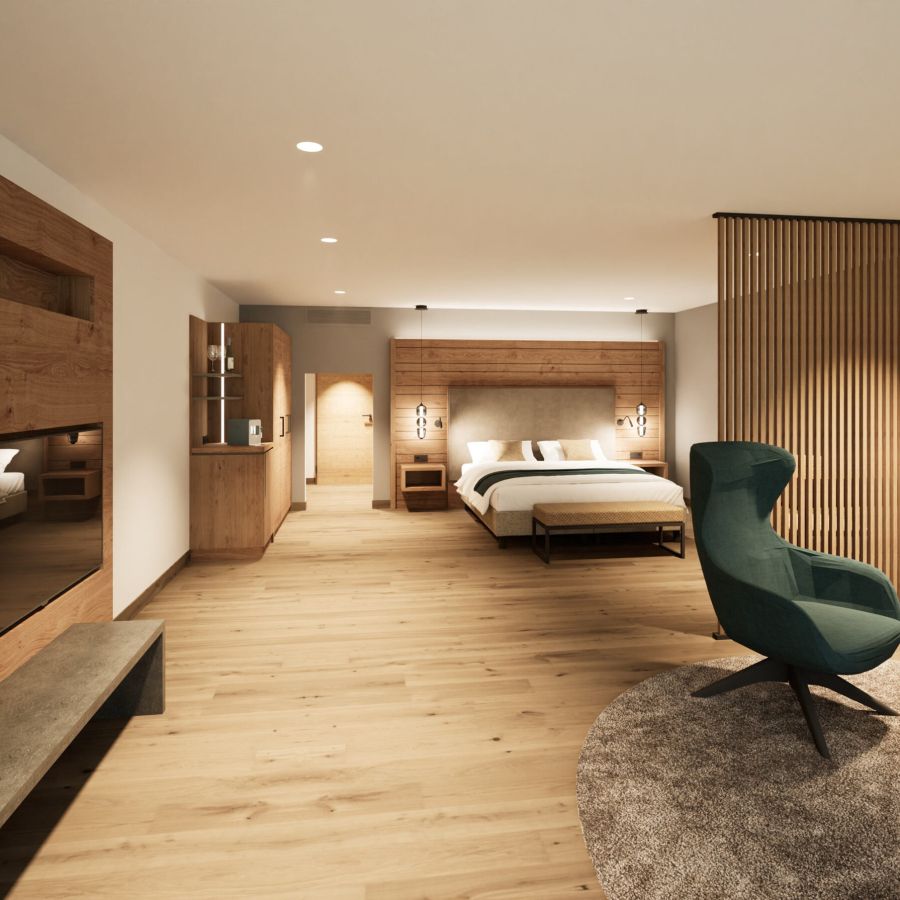Junior Suite mit Doppelbett, grünem Ohrensessel und heller Holzverkleidung im Hotel Churfürstenhof